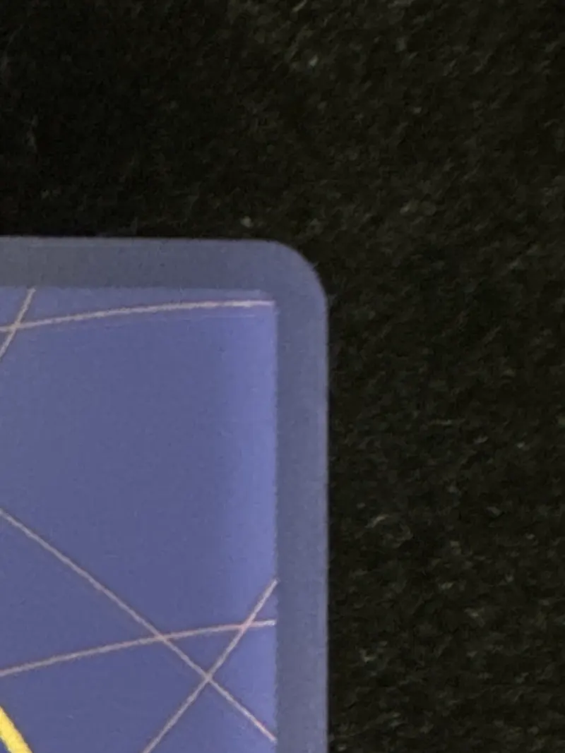 The same top-right corner of the Nami OP01-016 card back after corner correction, photographed under normal light
